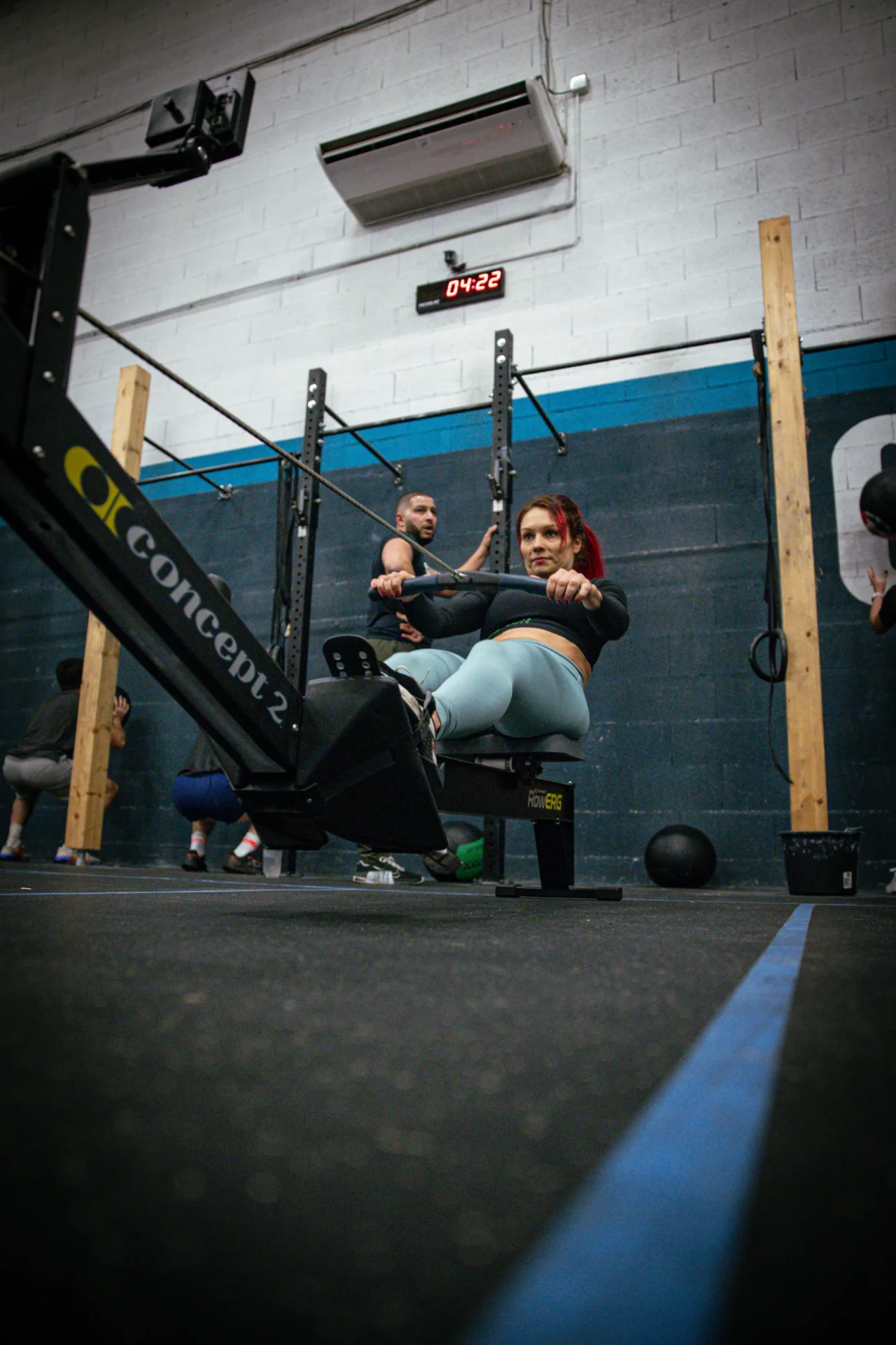 Adhérente en plein effort sur un rameur Concept2 pendant un WOD