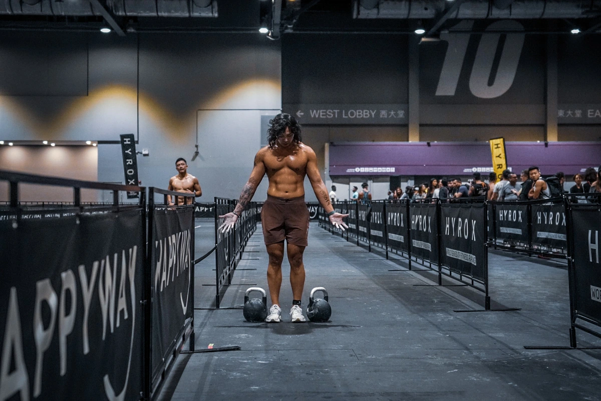 Farmers carry avec kettlebells lors d'une épreuve Hyrox