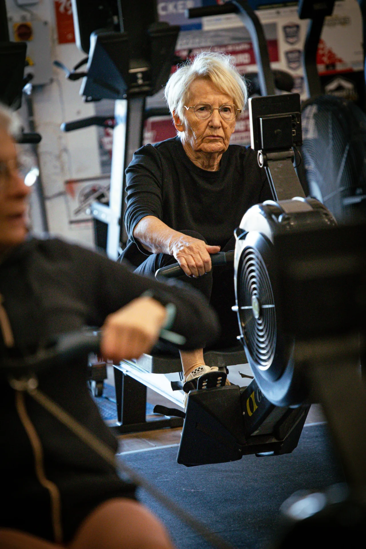 Adhérente senior au rameur pendant un cours de CrossFit adapté à Saint-Étienne