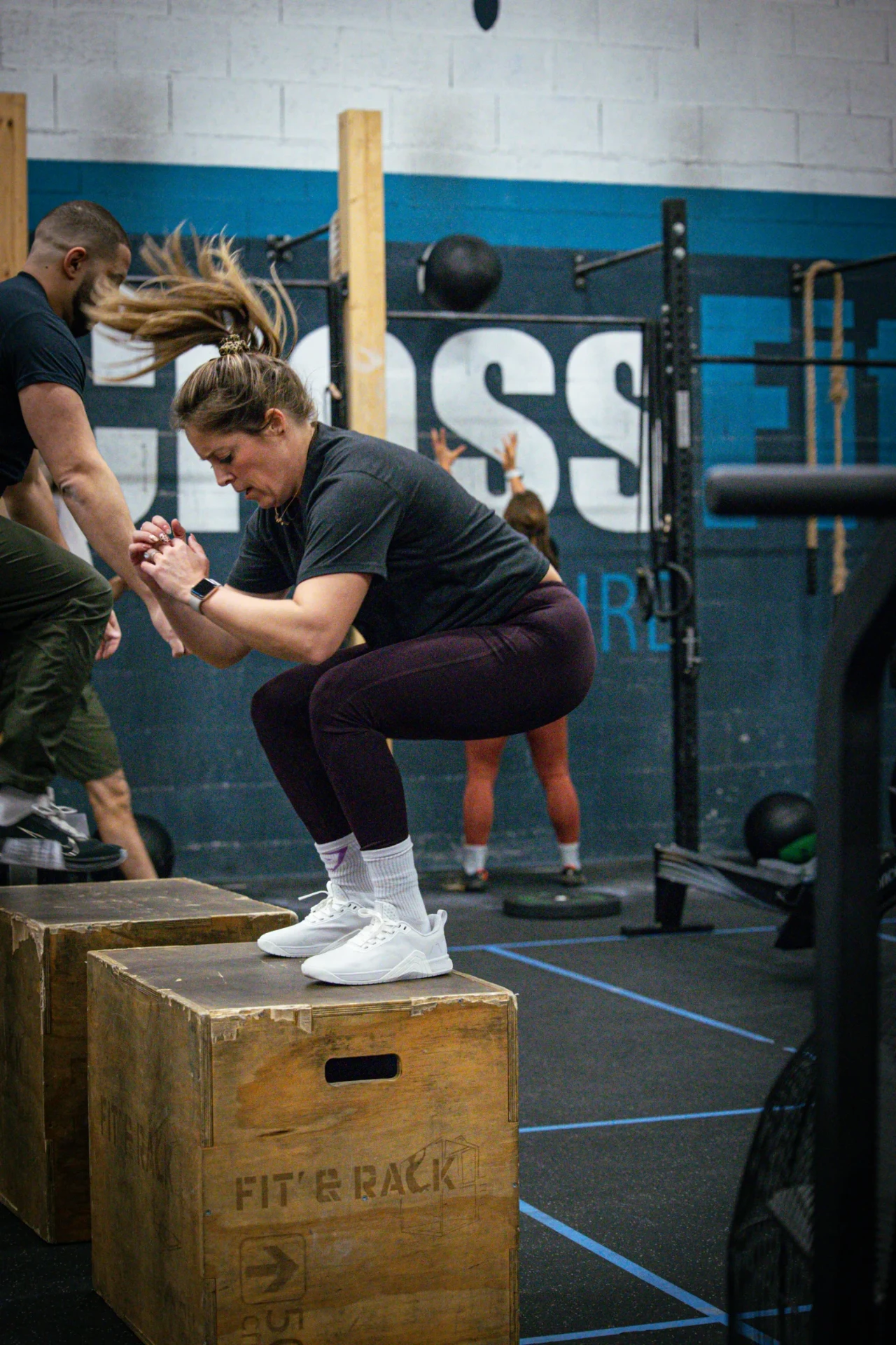 Athlète en réception de box jump pendant un WOD