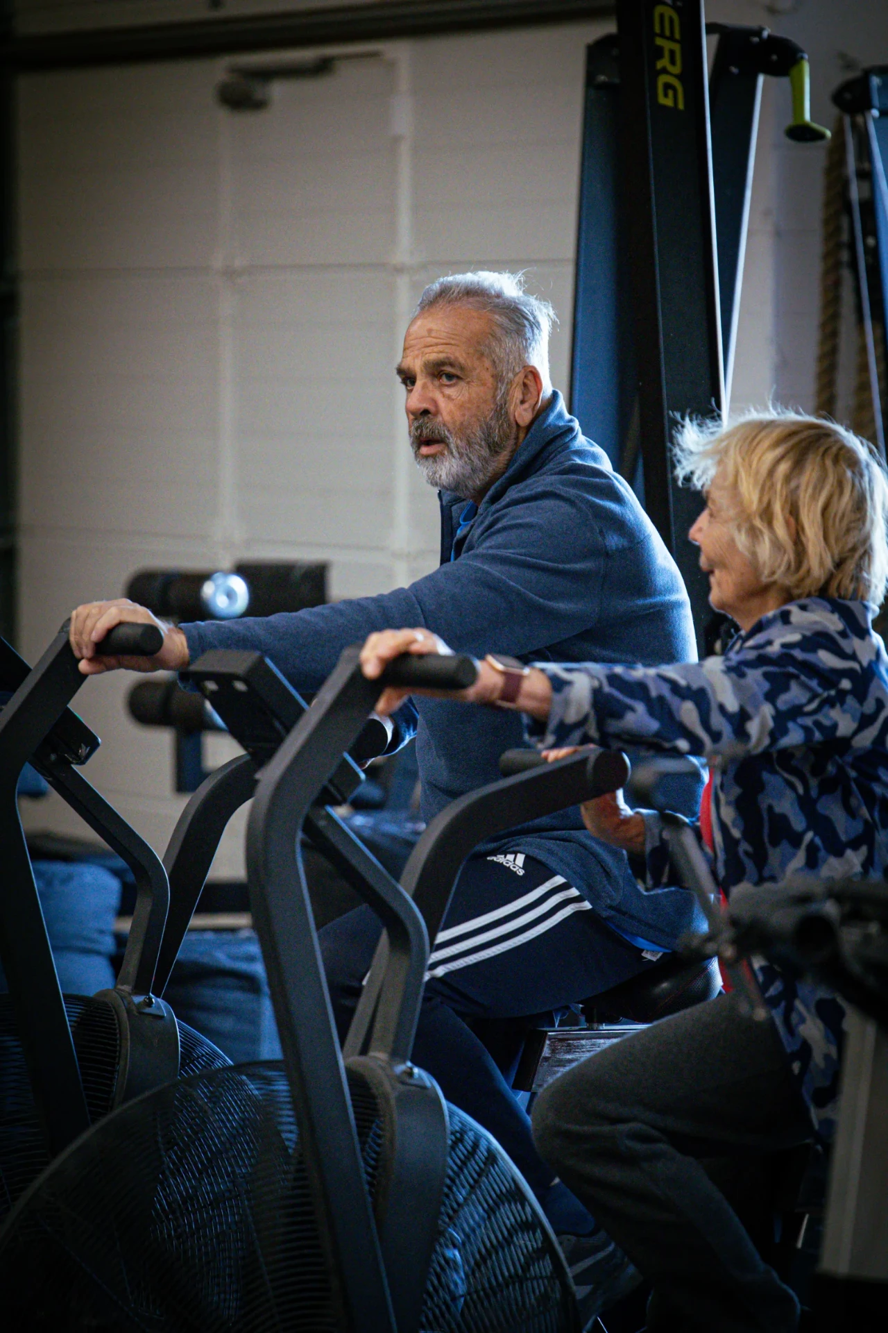 Adhérents seniors pédalant sur les vélos à air dans la box CrossFit Blue Bird