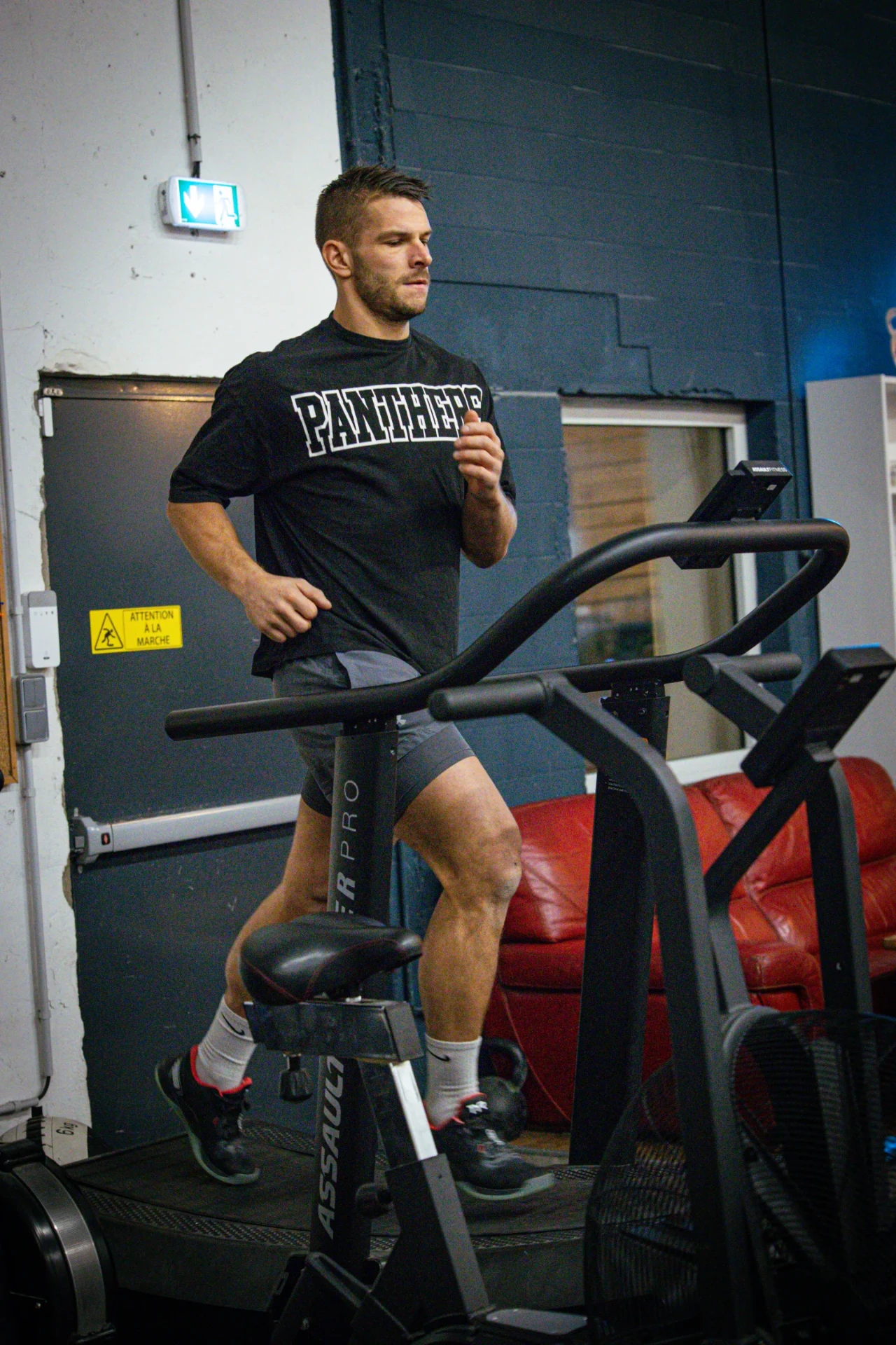 Course sur tapis à traction manuelle dans la salle de CrossFit