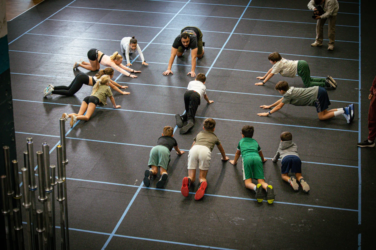 Groupe d'enfants en étirement au sol avec leur coach à la box CrossFit Blue Bird