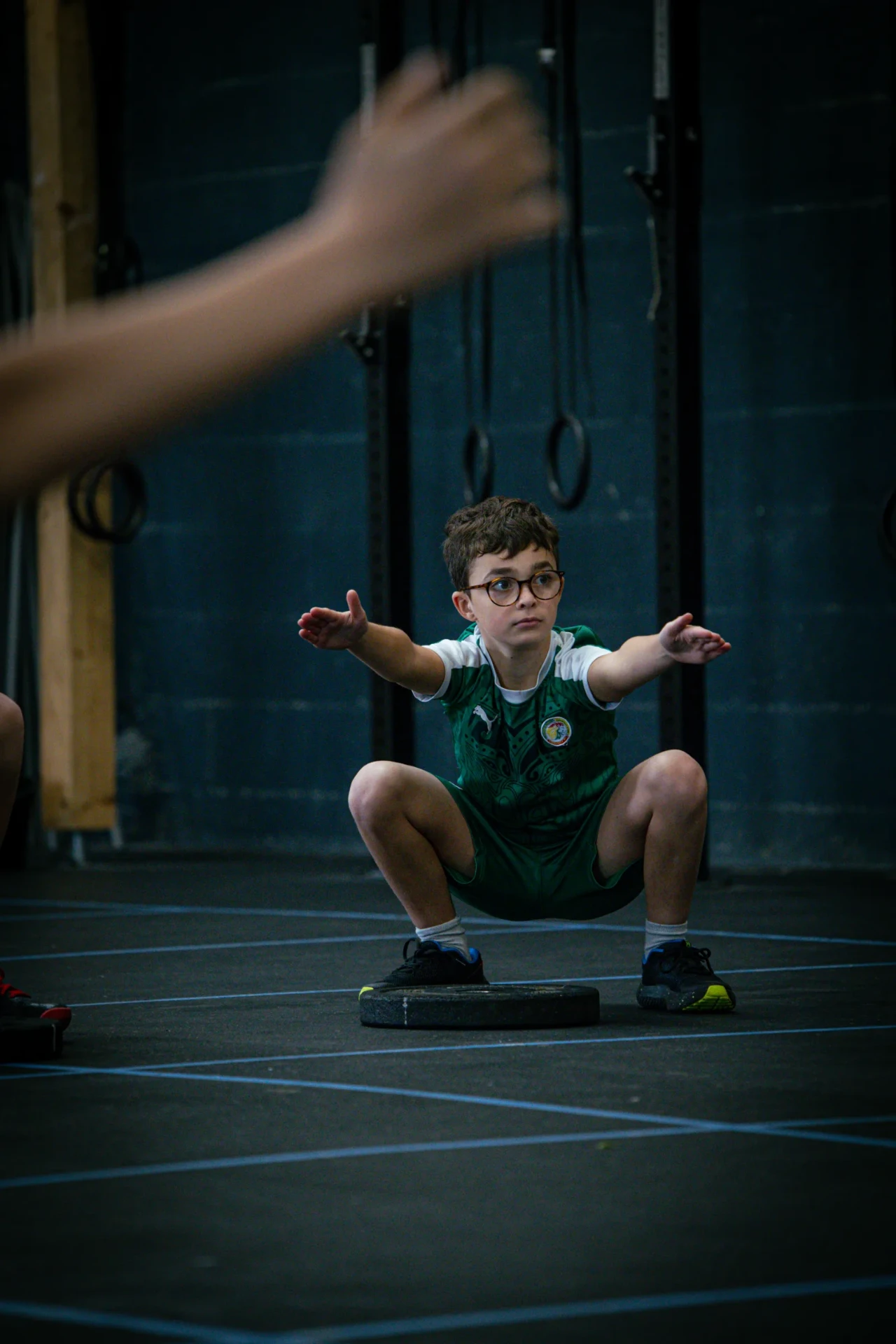 Enfant en squat pendant un cours de CrossFit pour enfant à Saint-Étienne