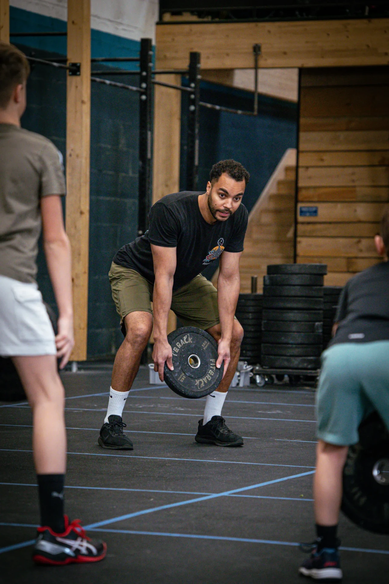 Coach montrant la technique de soulevé aux ados pendant le cours CrossFit Teens à Saint-Étienne