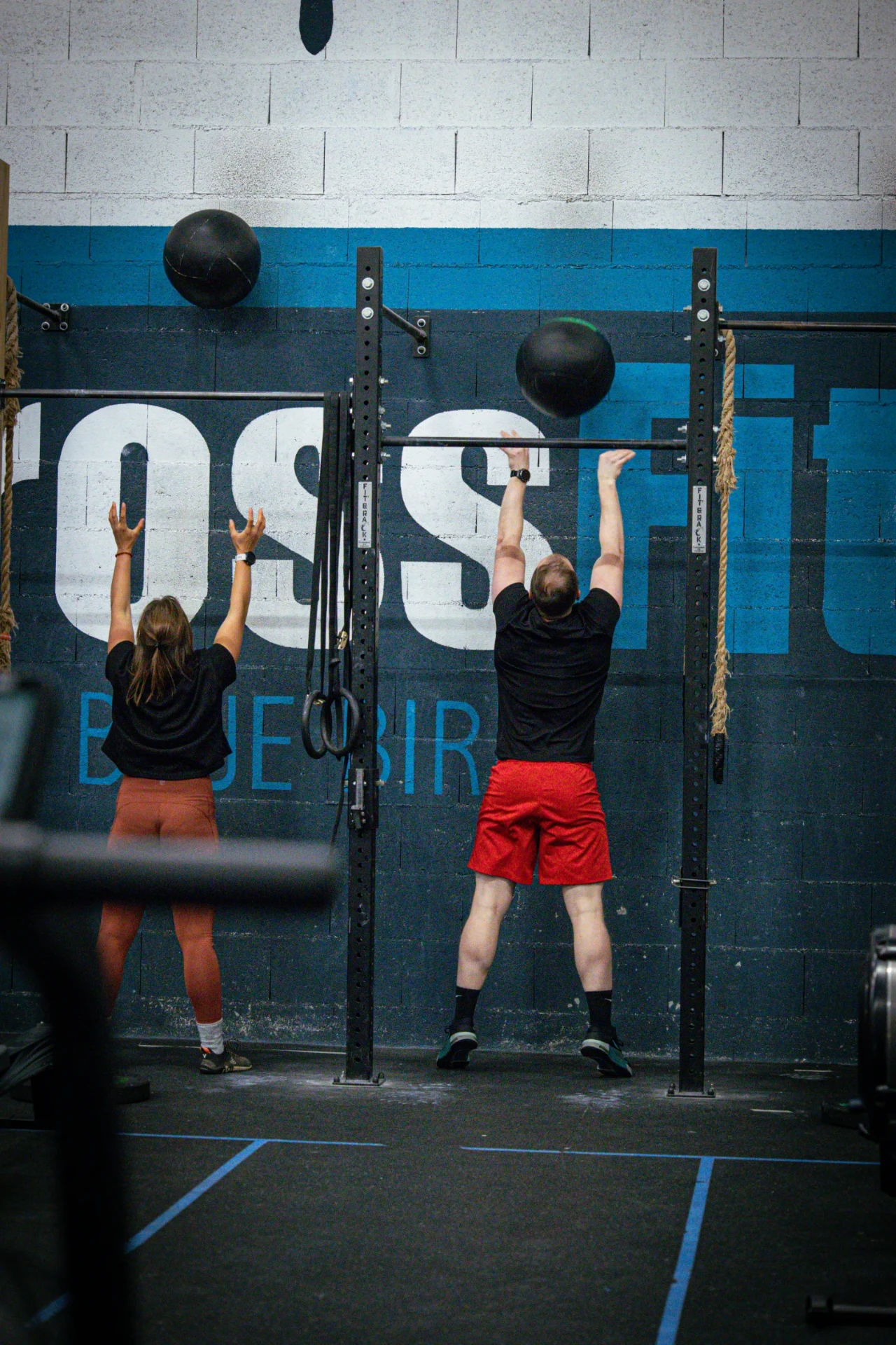 Wall balls devant la fresque CrossFit Blue Bird pendant un cours collectif