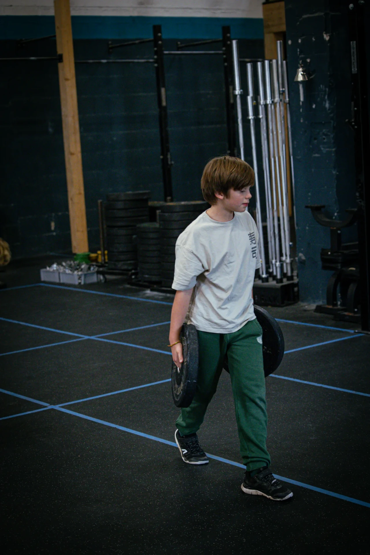Ado transportant des disques pendant un circuit CrossFit Teens