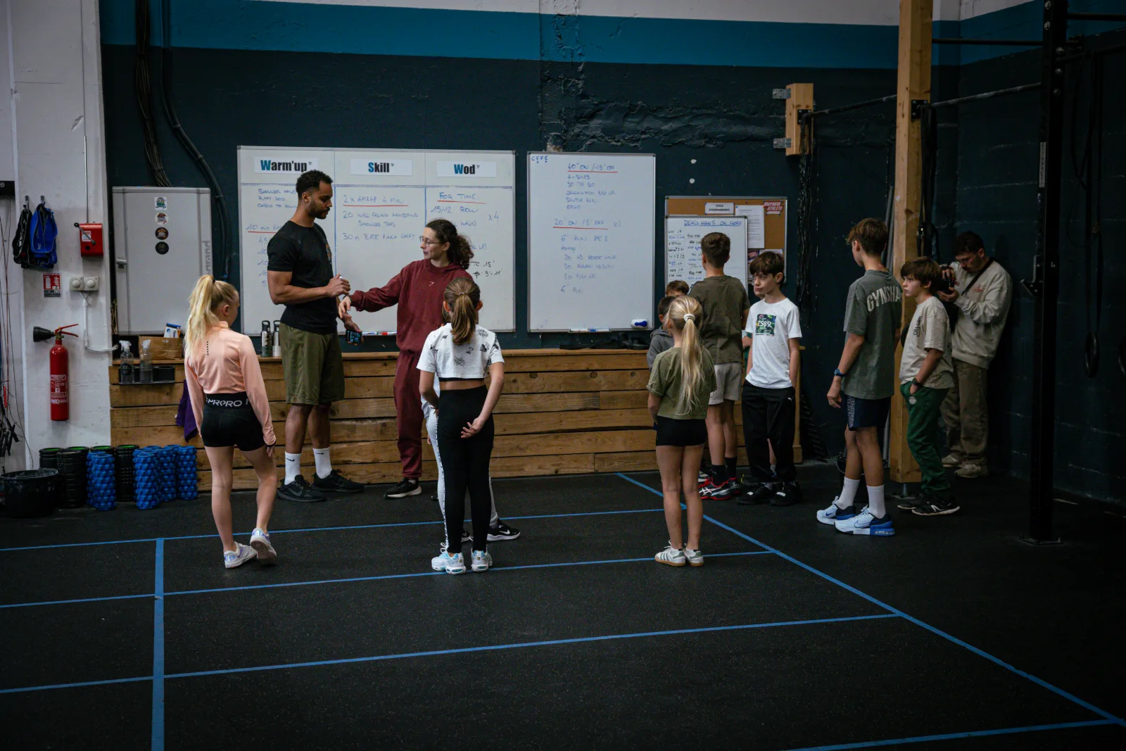 Coachs présentant le WOD du jour aux enfants du cours CrossFit Kids à Saint-Étienne
