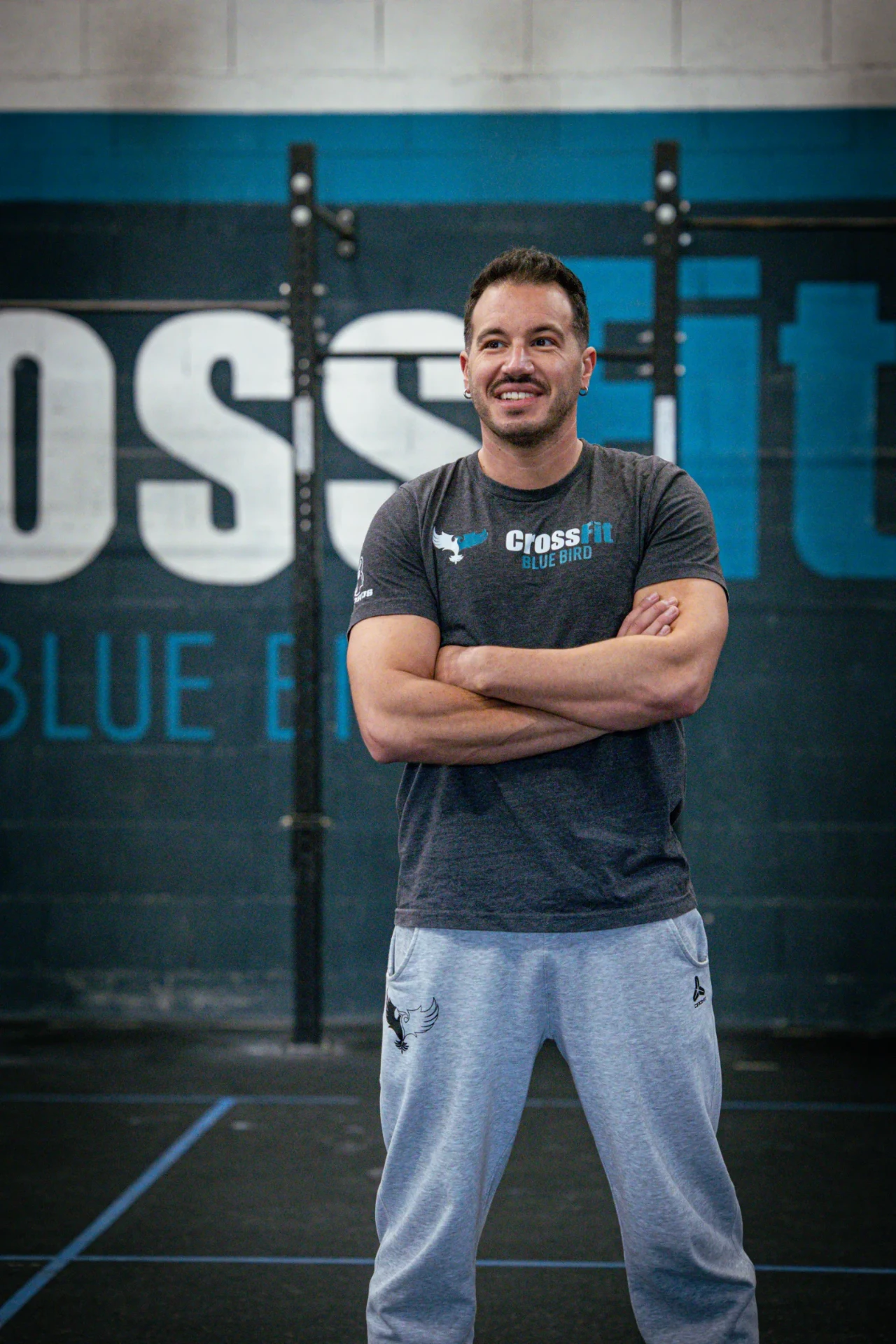 Coach de CrossFit Blue Bird souriant devant le mur de la salle à Saint-Étienne