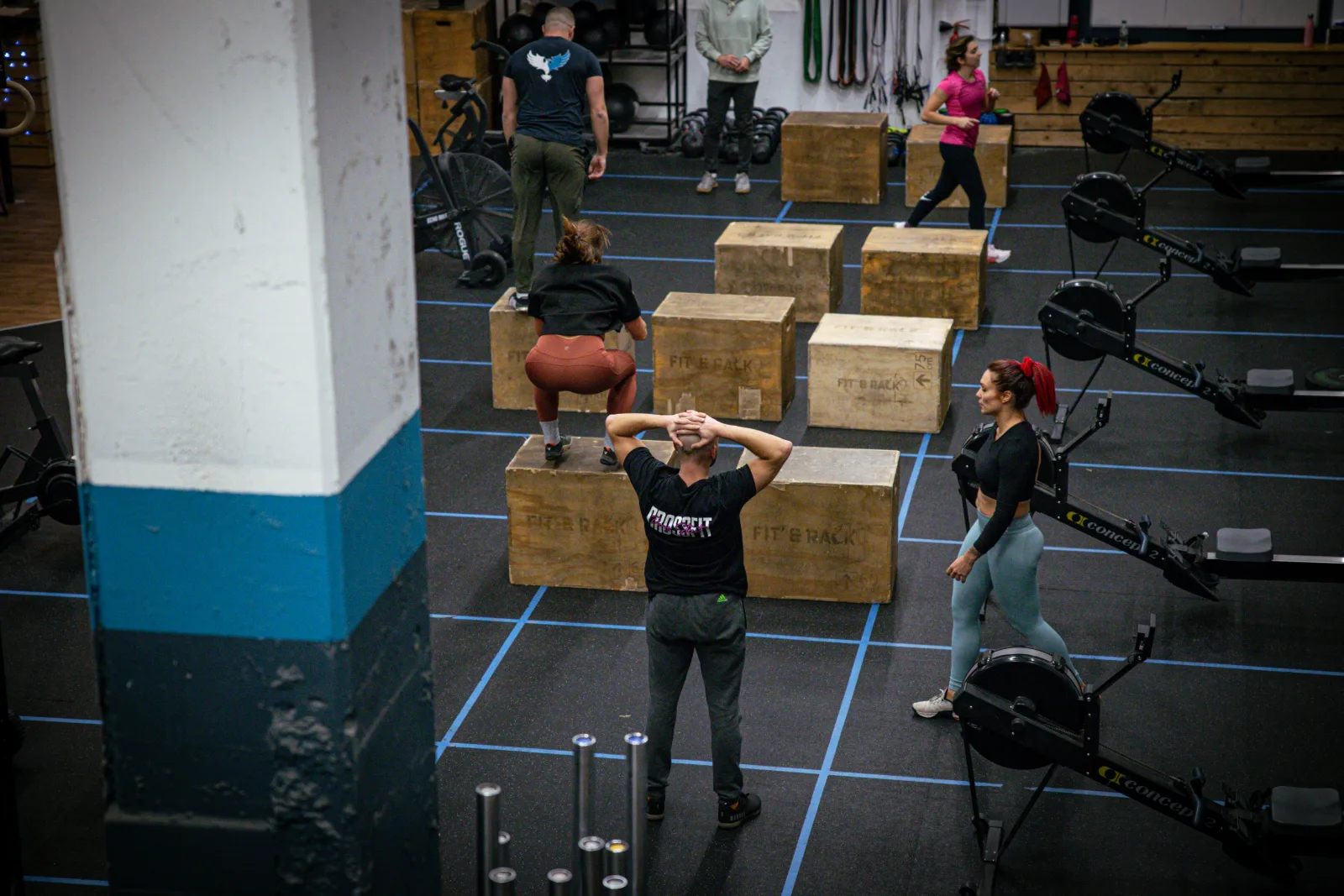 Coach et athlètes sur les box jumps dans la box de CrossFit