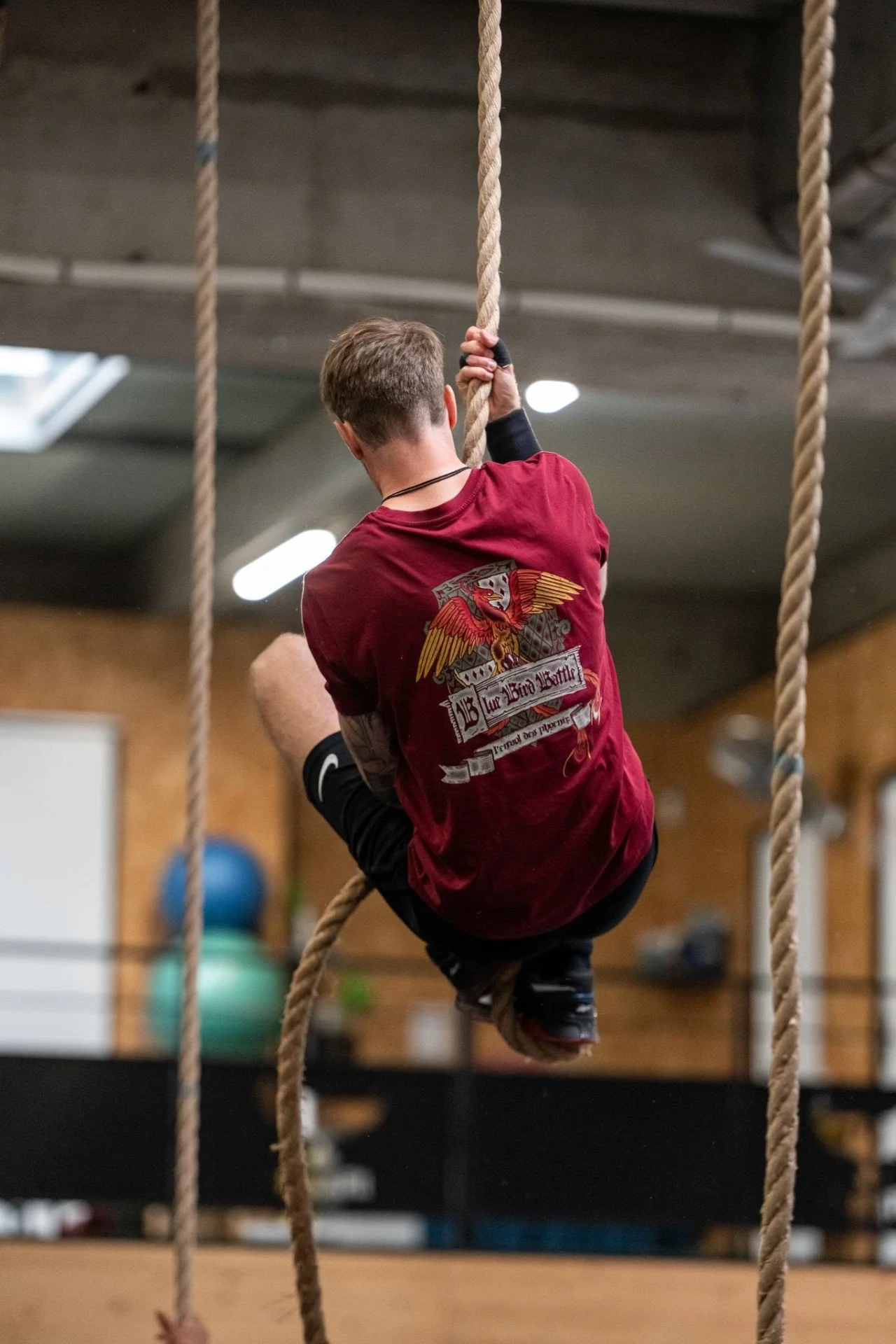 Adhérent en montée à la corde dans la salle de CrossFit à Saint-Étienne